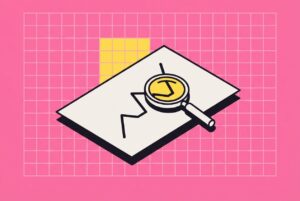 Loupe posée sur une feuille de courbes, fond rose